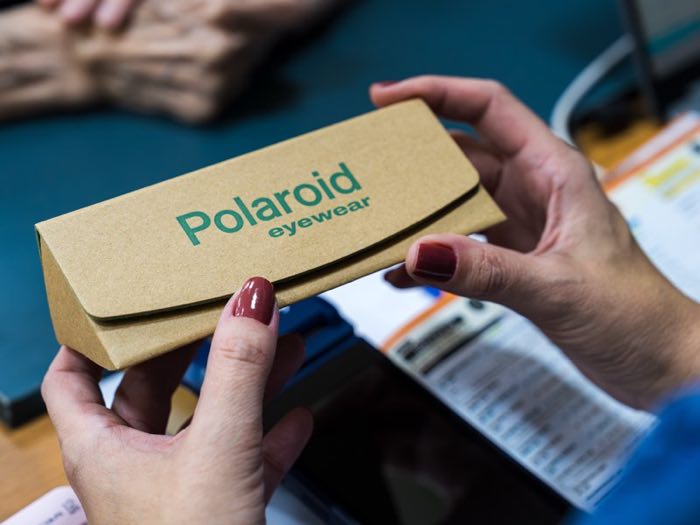 Cliente recebendo o estojo dos óculos no balcão